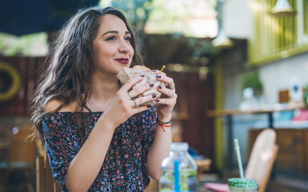 Woman enjoys plant-based burger from food service distributor